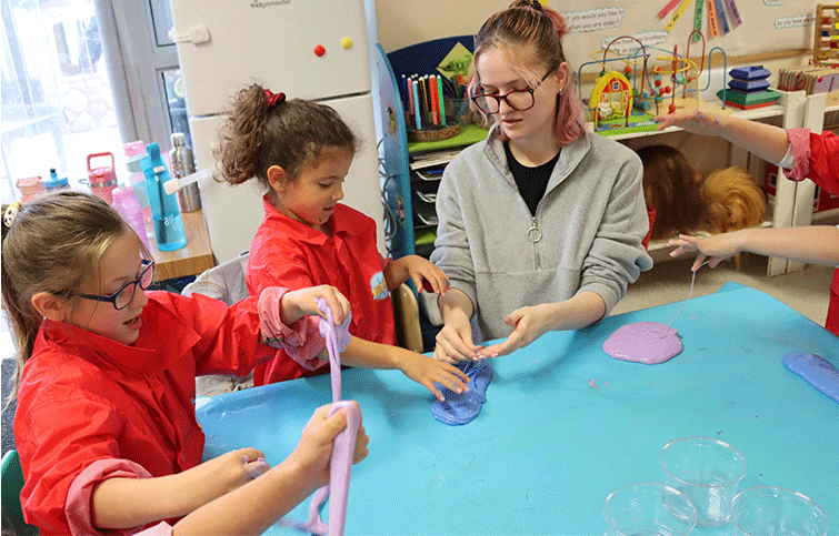 Children in a creation station holiday camp playing with slime and being creative