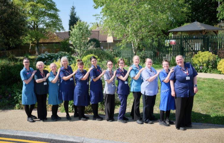 Nurses standing in front of the hospice garden