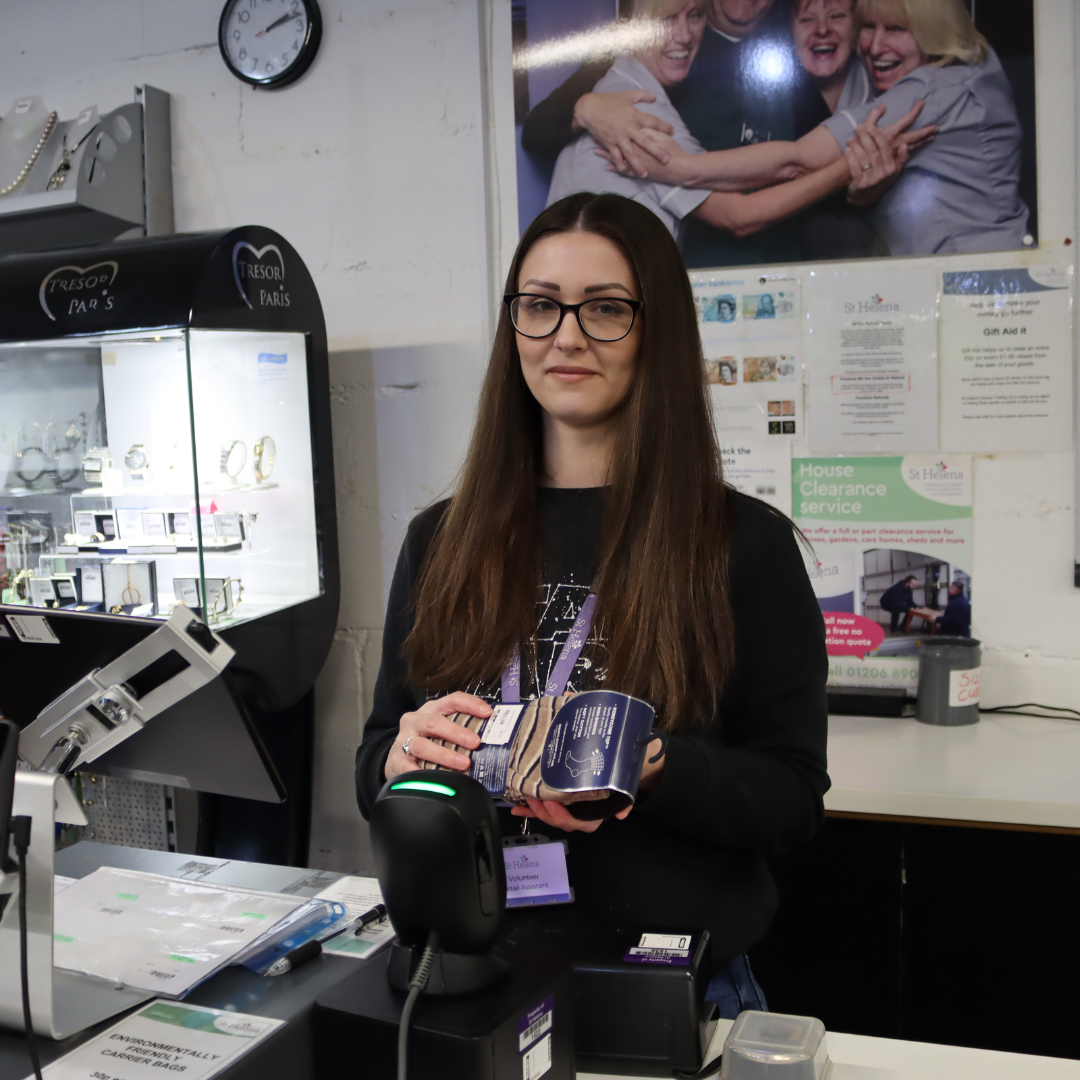 A retail volunteer scanning an item through the till