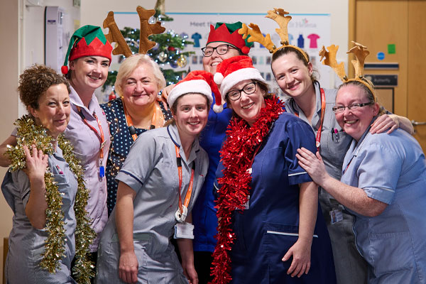 St Helena team smiling dresses in Christmas tinsel festive wear