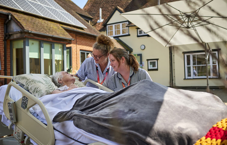 Image: St Helena Hospice patient with nurses in the garden