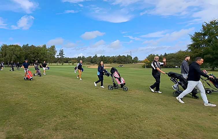 Happy people walking along a golfing green