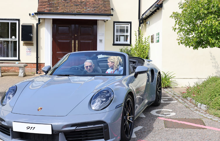 Image: Tony sits in a Porsche outside St Helena Hospice