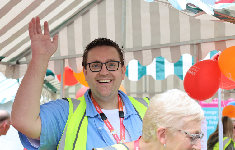A fundraiser waving at the camera