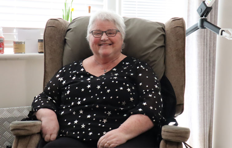 Image: Rosie smiling as she can now sit in her chair thanks to Hospice in the Home support