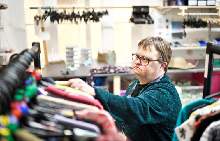 retail volunteer organising clothes on a rack
