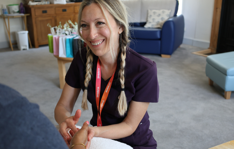 A complementary therapist giving a hand massage treatment  to a patient