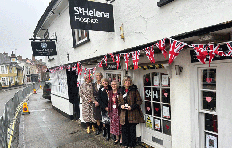 Image: Volunteers from the St Helena Hospice charity on Dedham high street waiting for the King and Queen to visit