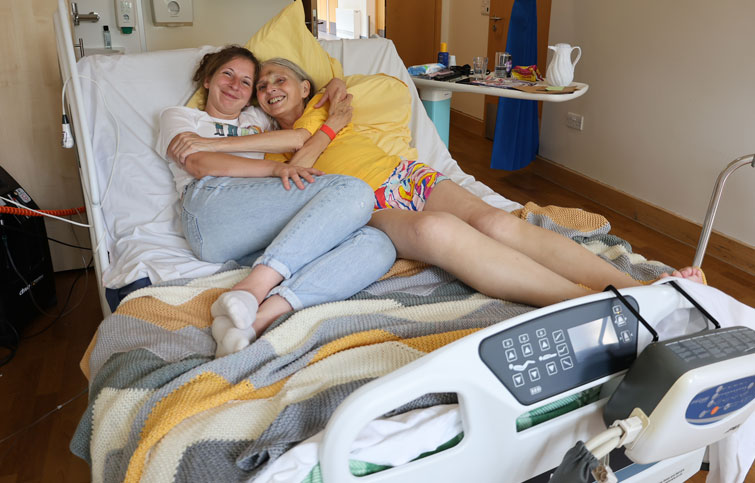 Image: Catherine cuddling her daughter on the cuddle bed at St Helena Hospice