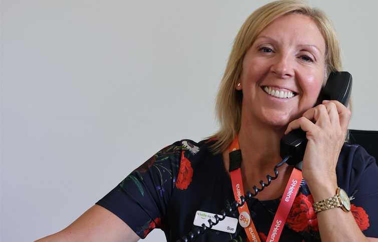 Image: Sue volunteering on reception at St Helena Hospice