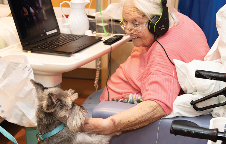 Janet enjoying a visit from a PAT dog