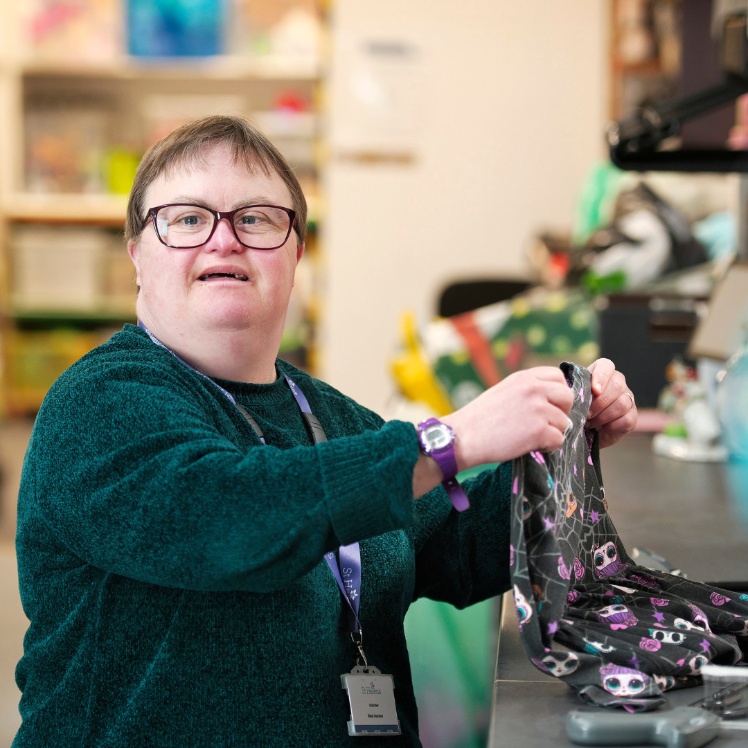 A retail volunteer sorting through a pile of donations