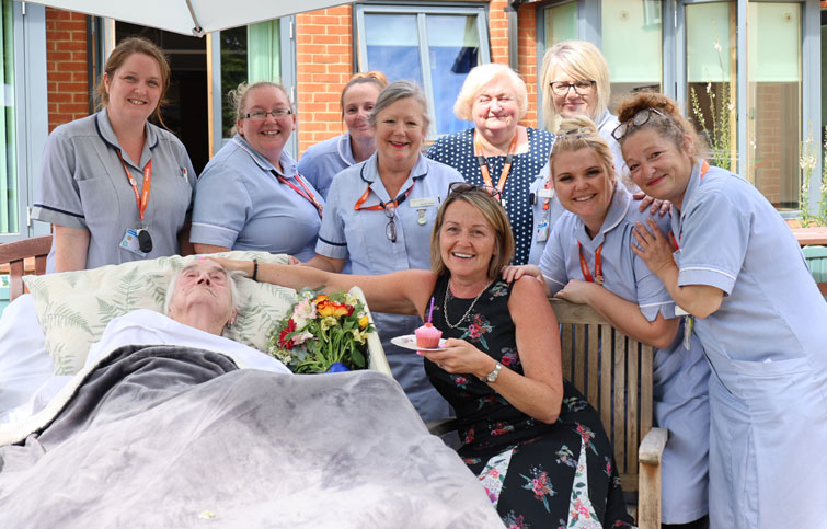Image: St Helena Hospice patient and daughter with nurses in the garden