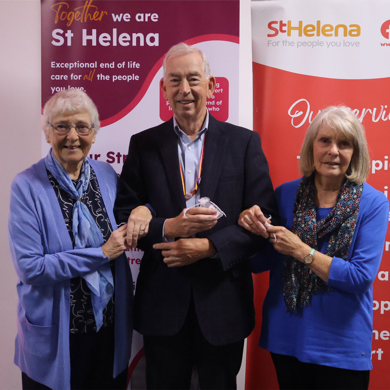 Three St Helena Hospice volunteers linking arms